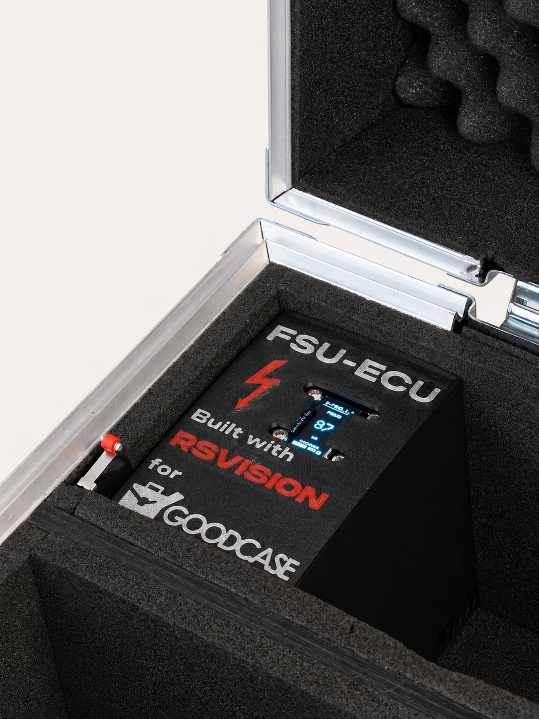 TM-01 vnitřek shora — desky, baterie, OLED na víku, stejné světlo jako D-TRC-1 série pro vizuální kontinuitu